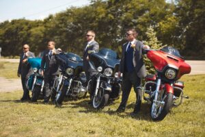 Groom & groomsmen pose for wedding day photos with motorcycles at a garden wedding near Ann Arbor