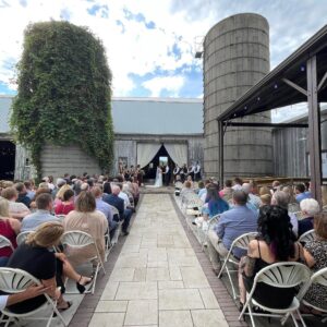 Wedding guests watch the bride & groom exchange vows at a spring wedding venue near Ann Arbor